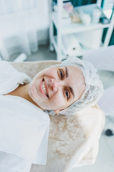 Yüzünde bir maske olan, saç bonesi takmış ve gülümseyen bir kadın.