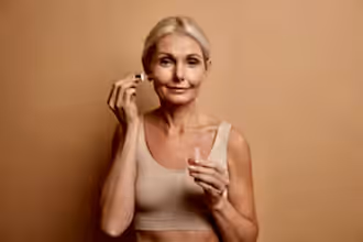 Yüzüne serum uygulayan yaşlı kadın